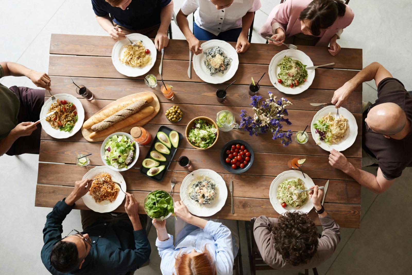 A top-down view of a diverse group enjoying a meal together, showcasing inclusivity and community spirit.